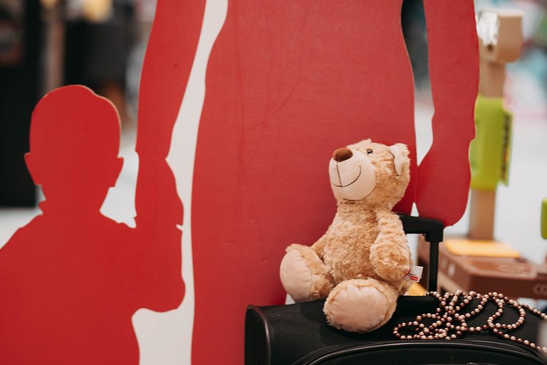 Silhouette von Frau mit Kind an er einen Hand und Koffer an der anderen Hand